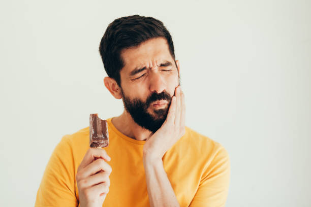 istock Man have sensitive teeth with ice on white background 1061051460