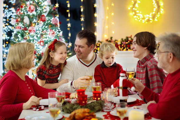 istock Family with kids having Christmas dinner at tree 1061052404