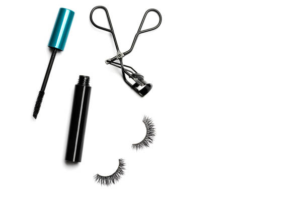 Mascara, eyelash curler and false eyelashes on white background
