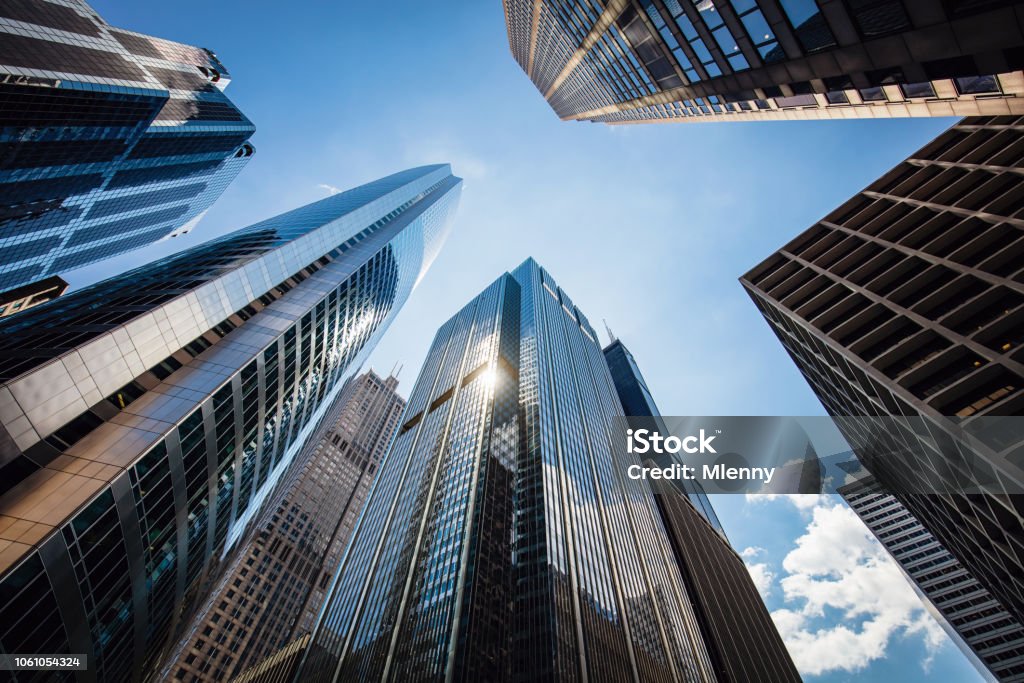 Chicago Urban Skyscrapers USA Modern urban skyscrapers in downtown Chicago from below to the blue summer sky. Sun reflecting in the glass facades of the urban futuristic buildings. Chicago, Illinois, USA Building Exterior Stock Photo