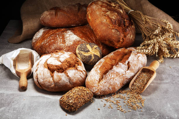 istock Different kinds of bread and bread rolls on board from above. Kitchen or bakery 1061059098