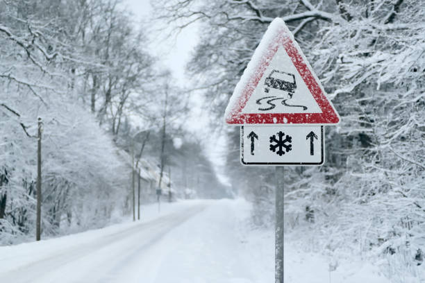 conducción de invierno - fuertes nevadas en un camino rural. conducción en él llega a ser peligroso... - road street sign slippery fotografías e imágenes de stock