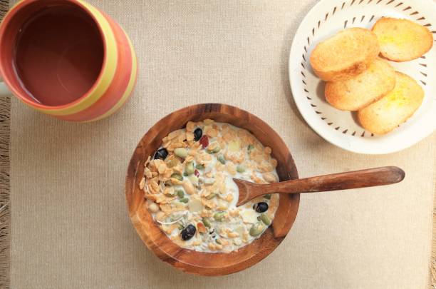 Healthy breakfast, muesli (granola), serial, tea and bread with wood plate