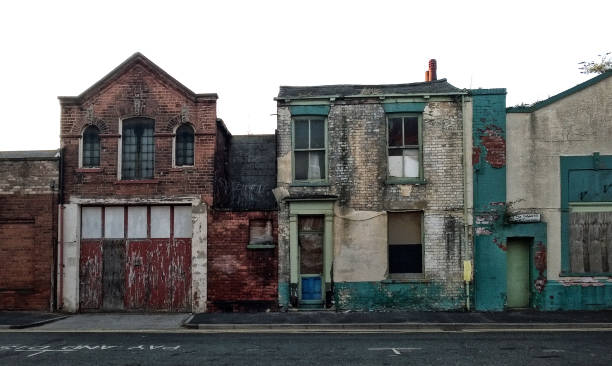 street of long abandoned and derelict collapsing houses and commercial buildings A street of long abandoned and derelict collapsing houses and commercial buildings run down neighborhood stock pictures, royalty-free photos & images