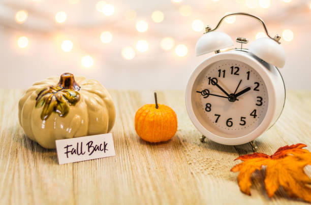 istock Fall Back Daylight Saving Time concept with white clock and autumn leaves 1061079774