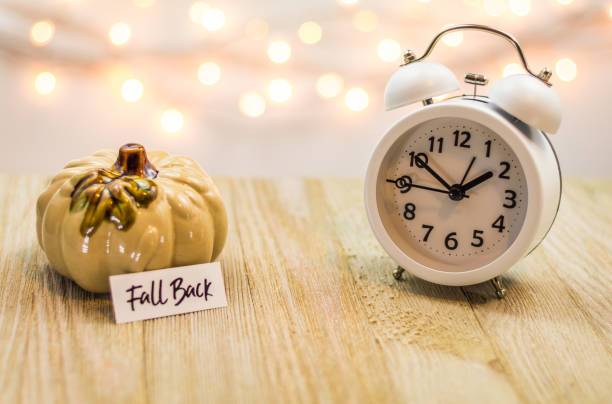 istock Fall Back Daylight Saving Time concept with white clock and autumn leaves 1061079788