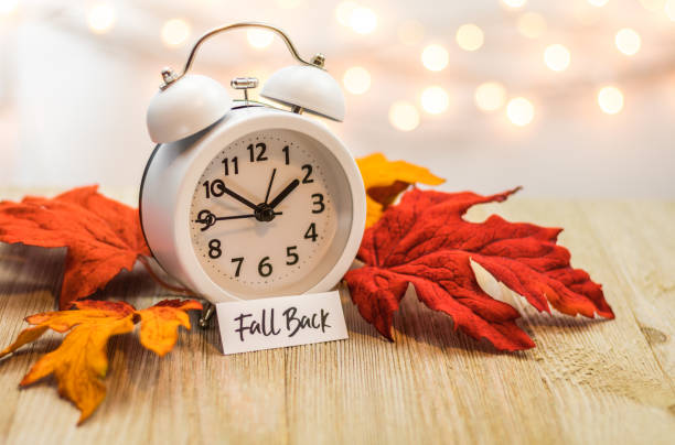 istock Fall Back Daylight Saving Time concept with white clock and autumn leaves 1061080860
