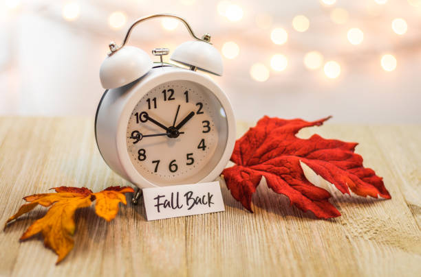 istock Fall Back Daylight Saving Time concept with white clock and autumn leaves 1061080902