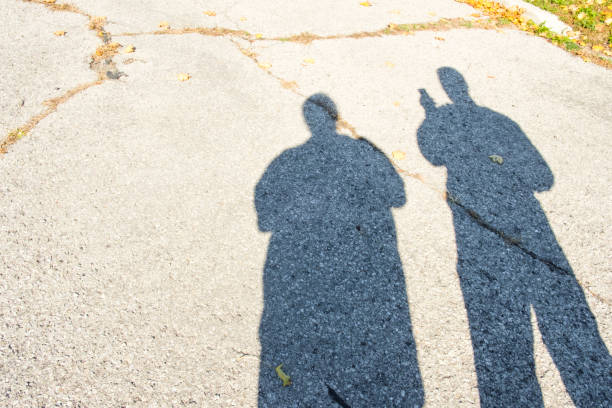 istock Shadows Of Two People On An Old Cement Road 1061082802