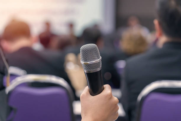 istock hand hold Microphone in meeting room for a conference 1061085660