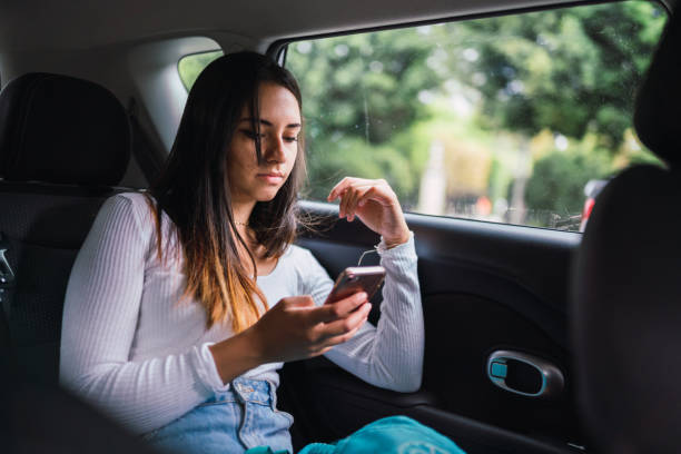 istock Young woman using smartphone in car 1061086374