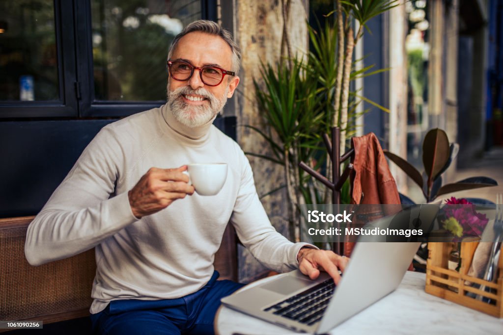 Handsome mature adult relaxing at the bar. Handsome mature man having a coffee at the bar 50-59 Years Stock Photo