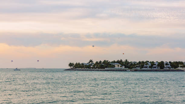 Houses by water at sunset with paragliders, in Key West, Florida, USA stock photo