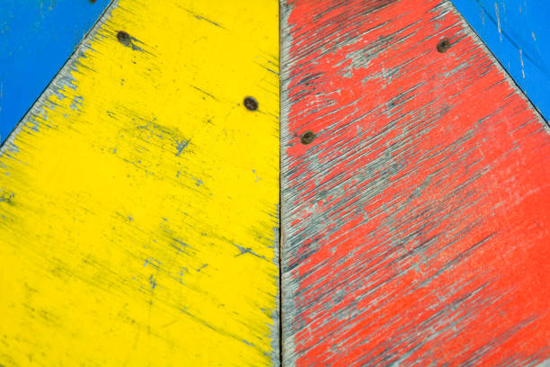 Yellow, blue and red paint on distressed old wooden background