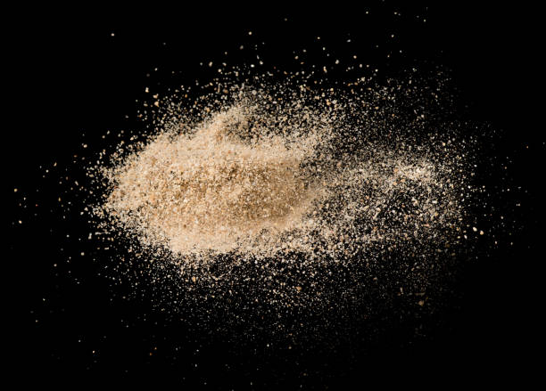 istock Sand flying explosion isolated on black background ,throwing freeze stop motion object design 1061113852