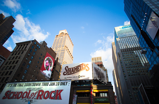 New York, NY: 42nd Street scene (near Times Square), with skyscrapers and billboards for the musical “School of Rock” and the TV show “Shameless.”