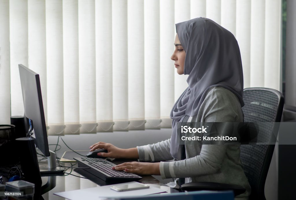Mujer musulmana asiática trabajando en oficina con ordenador - Foto de stock de Adulto libre de derechos