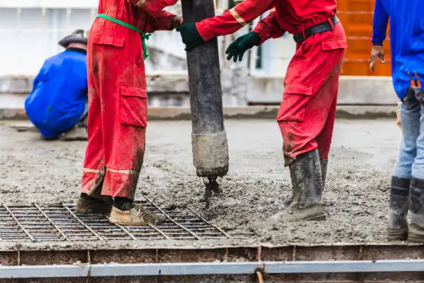 Construction men worker control boom concrete pump for building.