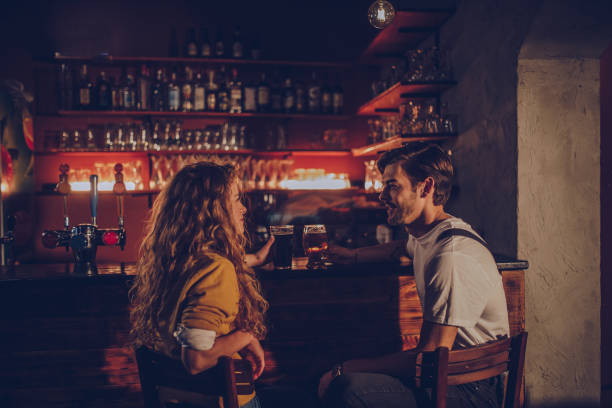 couple in pub - beer pub women pint glass imagens e fotografias de stock