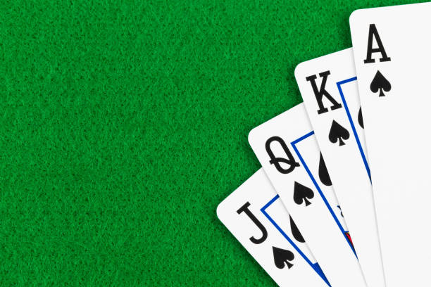 istock Royal flush poker playing cards on green felt background 1061166690