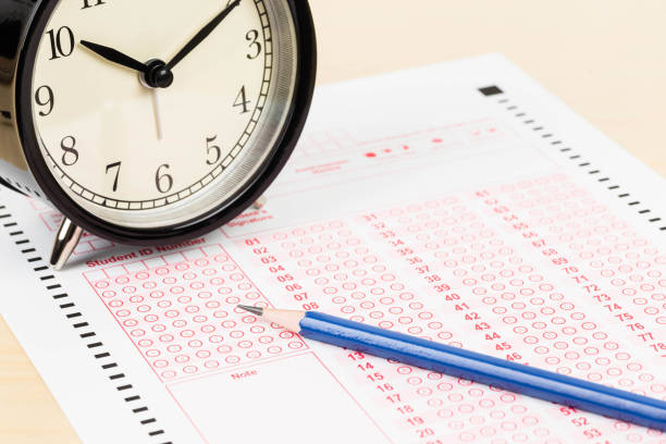 istock Answer sheet with pencil and alarm clock 1061167380