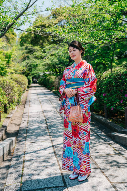 istock lady with colorful kimono standing in garden 1061179208