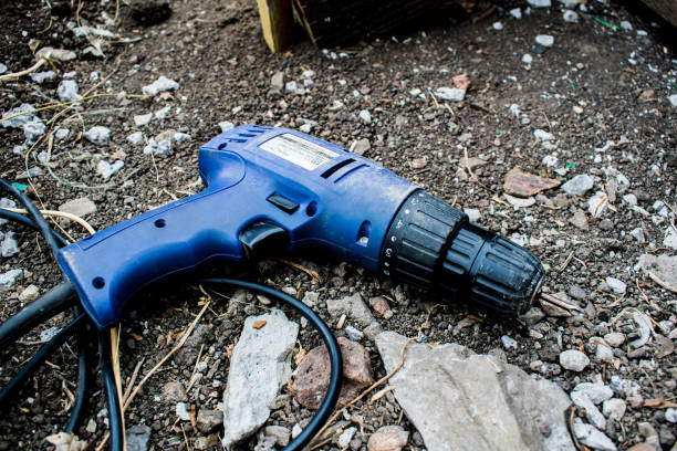 istock Working drill. Blue screwdriver, lying on the black ground 1061186442