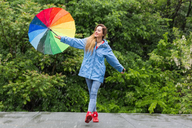 istock Woman with umbrella having fun in rainy day 1061188932