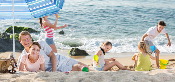 istock Parents and playing children on beach 1061189810