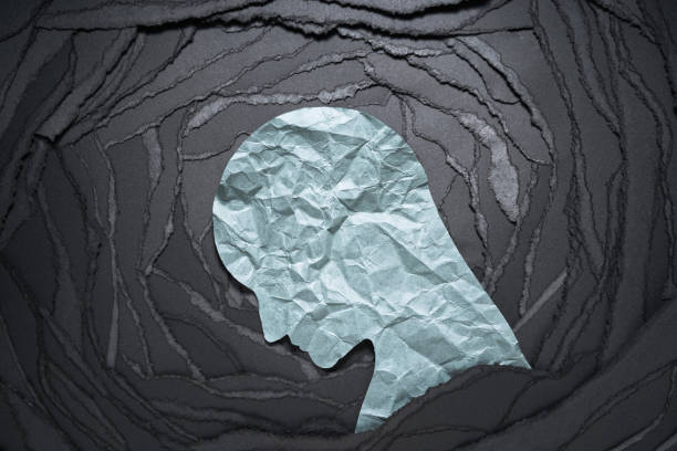 Silhouette of depressed and anxiety person head. Negative emotion image. Person head shaped paper on black torn paper background. anxiety stock pictures, royalty-free photos & images