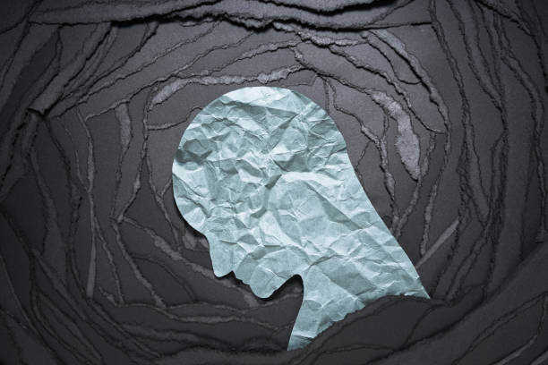 Silhouette of depressed and anxiety person head. Negative emotion image. Person head shaped paper on black torn paper background. silhouette of depressing stock pictures, royalty-free photos & images