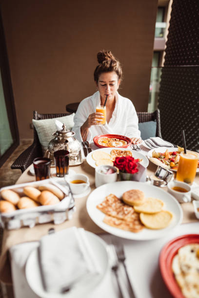 donna a tavola per la colazione a buffet con frutta - non alcoholic beverage comfort food snack dining table foto e immagini stock