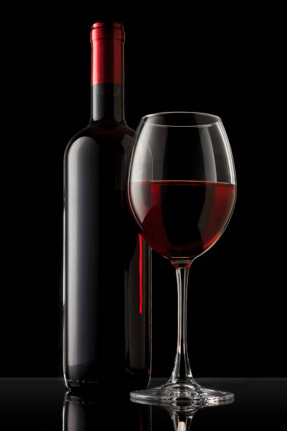 istock Red wine bottle and glass on the black background 1061211272