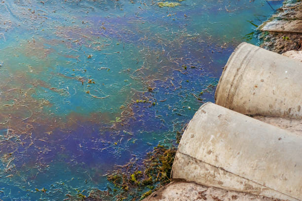 canos de esgoto na praia, mancha de óleo ou combustível na superfície da água, poluição de natureza por produtos químicos tóxicos, o conceito de mar sujo - water pollution chemical garbage plastic - fotografias e filmes do acervo