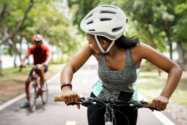 Cyclist couple riding bikes in a park Cyclist couple riding bikes in a park cycling helmet photos stock pictures, royalty-free photos & images