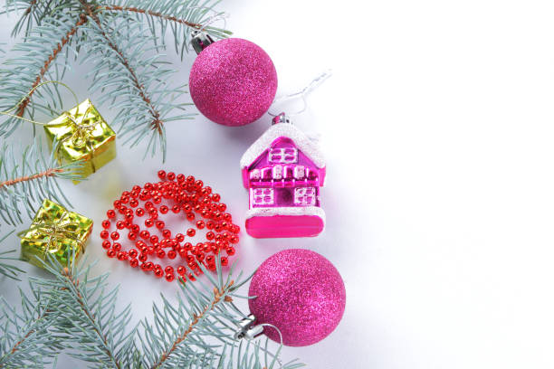 istock Christmas decorations. Spruce branches and holiday decorations on white background. Pink balls and toy house. Red necklace and golden boxes for festive Christmas tree 1061221372