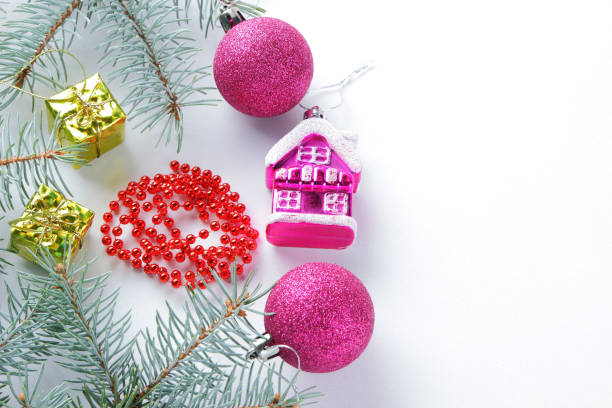 istock Christmas decorations. Spruce branches and holiday decorations on white background. Pink balls and toy house. Red necklace and golden boxes for festive Christmas tree 1061221398