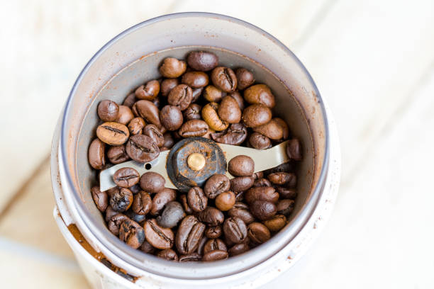 istock Fried coffee beans in a coffee grinder. Macro Vintage toning 1061221444
