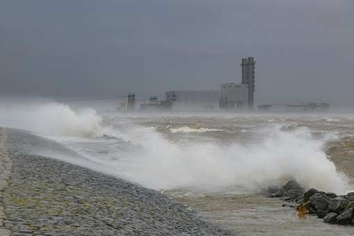 Off shore power station in the IJsselmeer lake in The Netherlands in a storm with big waves hitting the shore