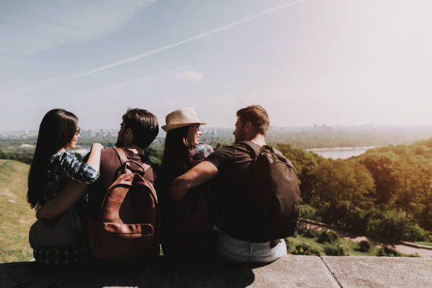 istock Young People with Backpacks Sitting in Park 1061230310