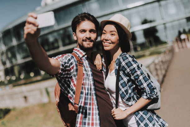 istock Young Happy Couple with Backpacks Taking Selfie 1061230366