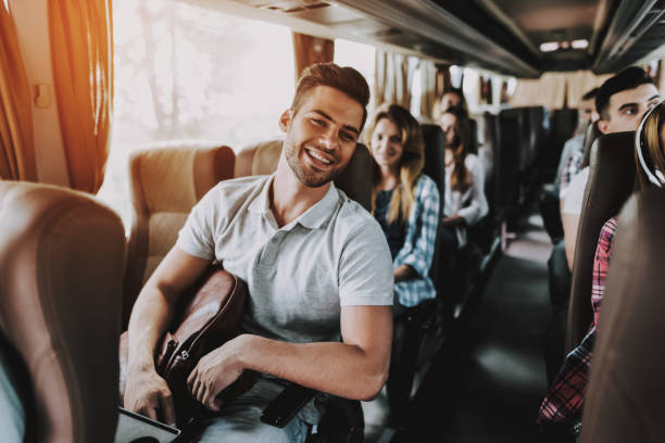 Young Handsome Man Relaxing in Seat of Tour Bus Young Handsome Man Relaxing in Seat of Tour Bus. Attractive Smiling Man Sitting on Passenger Seat of Tourist Bus and Holding Backpack. Traveling and Tourism Concept. Happy Travelers on Trip bus photos stock pictures, royalty-free photos & images