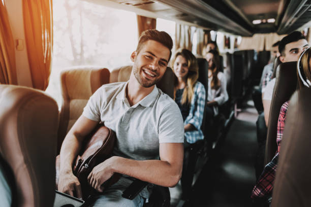 jovem homem bonito relaxante no banco do ônibus de turismo - autocarro - fotografias e filmes do acervo