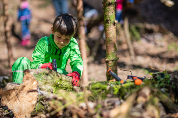 istock Boy inserting nail into wooden branch 1061236618