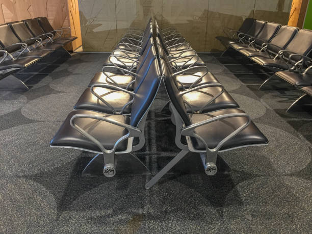 istock Two rowa of black leather chairs with metal hand rests lined up against each other 1061237004