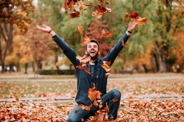 istock Young man throwing autumn leaves in the air 1061239258
