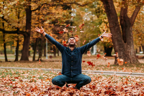 istock Young man throwing autumn leaves in the air 1061239260
