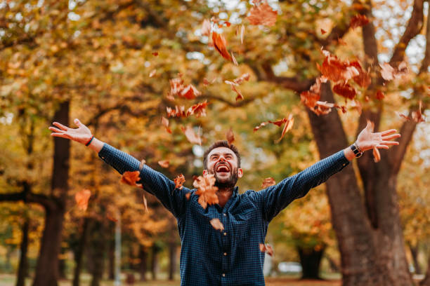 istock Young man throwing autumn leaves in the air 1061239268