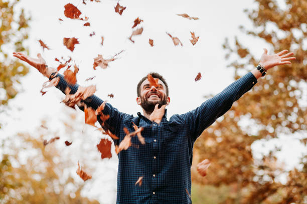 istock Young man throwing autumn leaves in the air 1061239288