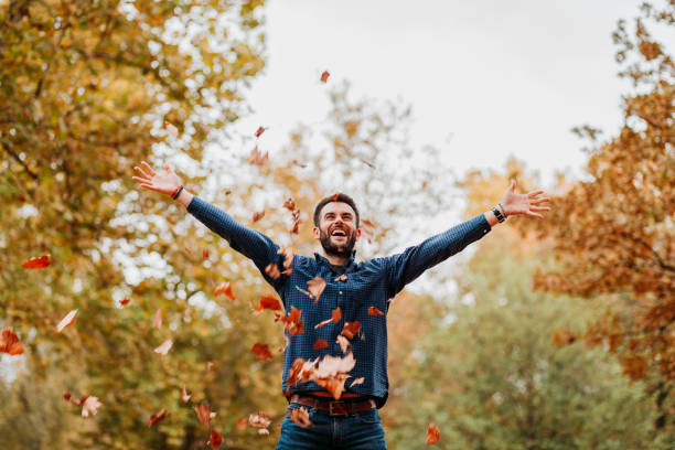 istock Young man throwing autumn leaves in the air 1061239302